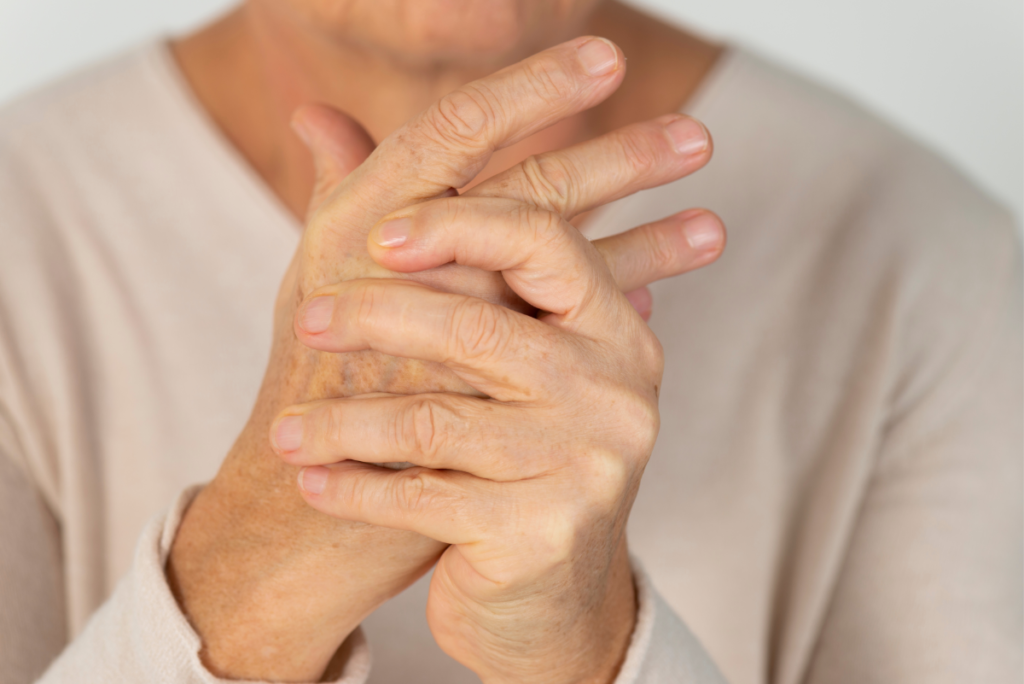 elderly woman grasping arthritic hands