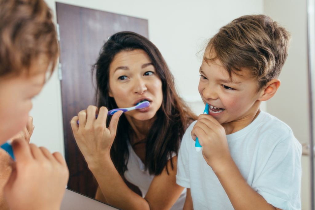woman and child brushing teeth