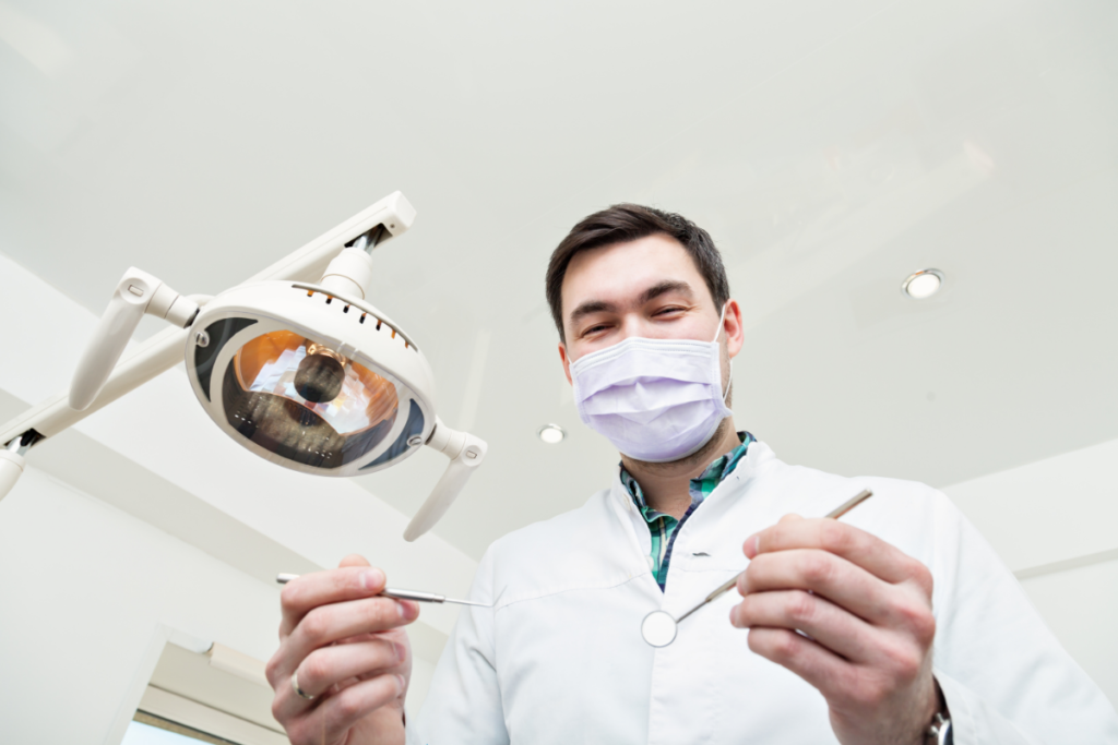 Dentist with a tool in the hands examining teeth